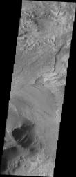 This image released on Oct 6, 2004 from NASA's 2001 Mars Odyssey shows an area on Mars in Candor Chasma. Layered surfaces and wind etched surfaces are present in this area.