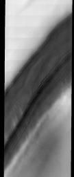 This image released on Oct 27, 2004 from NASA's 2001 Mars Odyssey shows the Martian north polar cap. Streamers of dust moving downslope over the darker trough sides showing the laminar flow regime coming off the cap. 