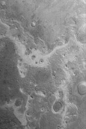 NASA's Mars Global Surveyor shows an exposure of layered material, probably sediment, on the floor of Shalbatana Vallis on Mars. Erosion has exhumed small impact craters and created round, layered buttes.