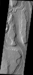 This image released on Nov 29, 2004 from NASA's 2001 Mars Odyssey shows the southern reach of Minio Vallis on Mars, a small fluvial channel located near the larger Mangala Vallis. Both channels are in the Tharsis region, in the area west of Arsia Mons.