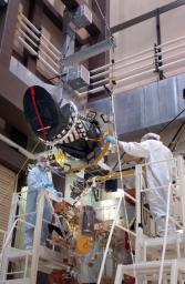Workers at Lockheed Martin Space Systems, Denver, position a telescopic camera for installation onto NASA's Mars Reconnaissance Orbiter spacecraft on Dec. 11, 2004.
