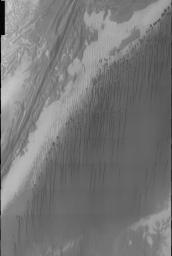 This image is part of THEMIS art month, taken by NASA's Mars Odyssey featuring a portion of Mars' landscape looking like a pleasant cloudburst falling from Martian dunes.
