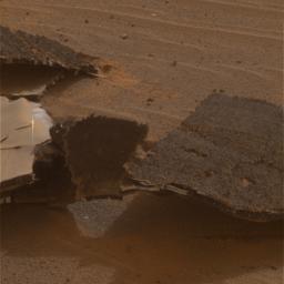 This image taken on Dec. 28, 2004 by NASA's Mars Exploration Rover Opportunity features an up-close view of the flank piece of the rover's broken heat shield laying on the red soil of martian terrain.