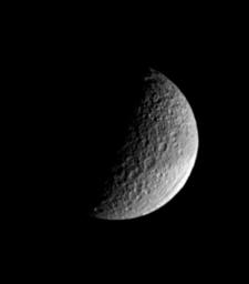 Saturn's moon Tethys, named for a sea goddess, shows off two of its more puzzling features in this image from NASA's Cassini spacecraft. Ithaca Chasma, near lower right, stretches for more than 1,000 kilometers (620 miles) across the moon's surface.