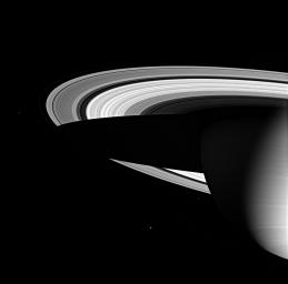 Three of Saturn's icy moons are seen here, along with the magnificent water-ice rings and the cold gaseous envelope of the planet's atmosphere. This image was taken in visible green light with NASA's Cassini spacecraft's wide-angle camera on June 1, 2005.