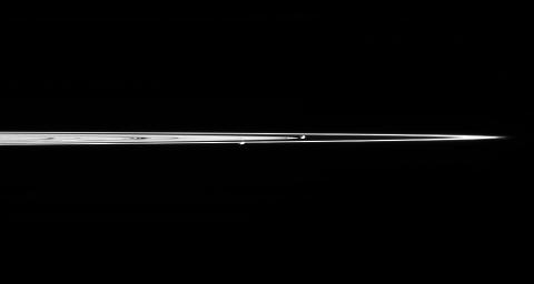 Saturn's moons Prometheus and Pandora are captured here in a single image from NASA's Cassini spacecraft, taken from less than a degree above the dark side of Saturn's rings.