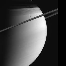 Saturn poses with Tethys in this image captured by NASA's Cassini spacecraft. The C ring casts thin, string-like shadows on the northern hemisphere. Above that lurks the shadow of the much denser B ring.