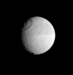 Saturn's moon Tethys displays its distinctive dark equatorial band here, along with two sizeable impact craters in the west. This image was taken in visible light with NASA's Cassini spacecraft's narrow-angle camera on July 10, 2005.