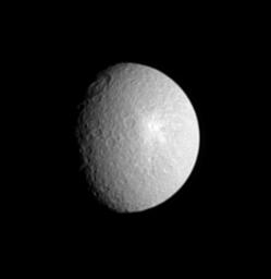 The giant Tirawa impact basin straddles the day and night boundary on Saturn's moon Rhea in this view from NASA's Cassini spacecraft.