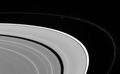 NASA's Cassini spacecraft looks up from beneath the ringplane to spot Prometheus and Atlas orbiting between Saturn's A and F rings. Prometheus is 102 kilometers (63 miles) across. Atlas is 20 kilometers (12 miles) across.