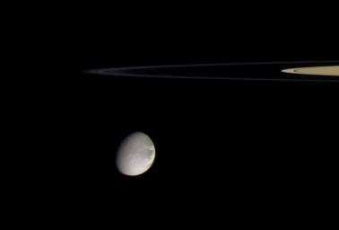 Saturn's moon Dione is about to swing around the edge of the thin F ring in this color view from NASA's Cassini spacecraft taken on Sept. 20, 2005. More than one thin strand of the F ring's tight spiral can be seen here.