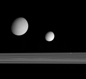 This excellent grouping of three moons Dione, Tethys and Pandora near the rings provides a sampling of the diversity of worlds that exists in Saturn's realm. This image was taken in visible blue light with NASA's Cassini spacecraft's narrow-angle camera.