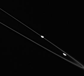 This spectacular image captured by NASA's Cassini spacecraft shows Prometheus (at right) and Pandora (at left), with their flock of icy ring particles (the F ring) between them.