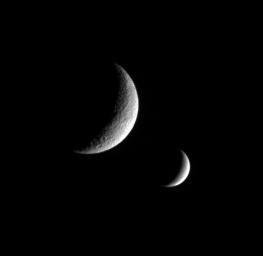 NASA's Cassini spacecraft captures this dual portrait of an apparently dead moon and one that is very much alive. Tethys, shows no signs of recent geologic activity. Enceladus is covered in fractures and faults and spews icy particles into space.