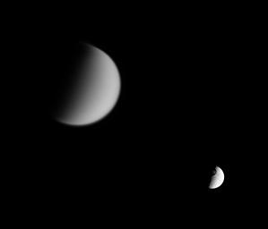 NASA's Cassini spacecraft looks toward Saturn's moon Tethys and its great crater Odysseus, while at the same time capturing veiled Titan in the distance (at left).