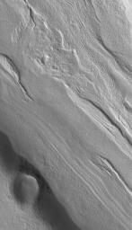 NASA's Mars Global Surveyor shows the floor of a fretted terrain valley in the Coloe Fossae region of Mars. Valleys found at north middle latitudes often have odd linear features on them. This picture shows a close-up of one such closed valley.