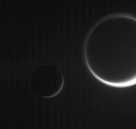 Ghostly details make this dark scene more than just a beautiful grouping of two Saturn moons, with Tethys on the left and Titan on the right. This view was obtained in visible light with NASA's Cassini spacecraft's narrow-angle camera on Jan. 19, 2006.