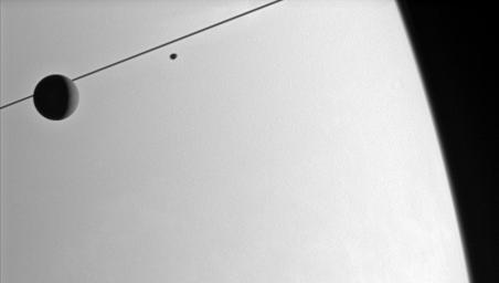 NASA's Cassini spacecraft looks toward the Saturnian horizon as Dione and Janus glide past.