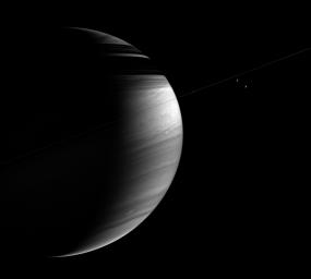 The tilted crescent of Saturn displays lacy cloud bands here along with a bright equatorial region and threadlike ring shadows on the northern hemisphere as seen by NASA's Cassini spacecraft.