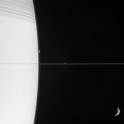Three of Saturn's moons are captured with the planet in this exquisite family portrait. At top, Saturn is bedecked with the shadows of its innermost rings as seen by NASA's Cassini spacecraft.