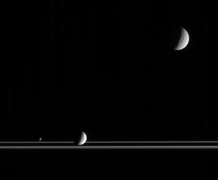 The three very different moons seen here provide targets of great interest for planetary scientists studying the Saturn system. Captured by NASA's Cassini, along with the rings, are Tethys at upper right, Enceladus below center and Janus at lower left.