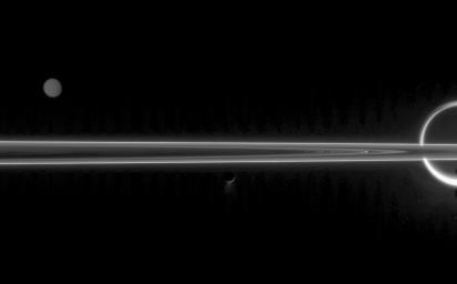 The real jewels of Saturn are arguably its stunning collection of icy moons. Seen here with the unlit side of the rings are Titan, Tethys and Enceladus with its fountain-like geysers. This image was captured by NASA's Cassini spacecraft.