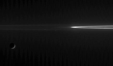 Two ring moons chase each other as their larger sibling looks on. This view from NASA's Cassini spacecraft shows Tethys at lower left, along with perpetually mingling Epimetheus at left of center, and Janus at center.