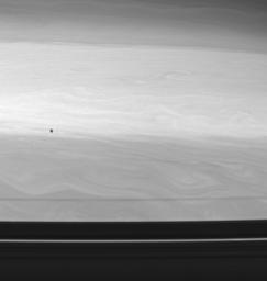 The shadow of Epimetheus, one of Saturn's co-orbital moons, races across the planet's restless cloud tops. This image was taken with NASA's Cassini spacecraft's wide-angle camera using a spectral filter sensitive to wavelengths of infrared light.