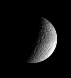 The ancient gorge of Ithaca Chasma carves a path across Saturn's moon, Tethys and continues out of sight over the moon's limb in this image from NASA's Cassini spacecraft.