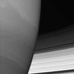 Saturn's B and C rings disappear behind the immense planet. Where they meet the limb, the rings appear to bend slightly owing to upper-atmospheric refraction as seen by NASA's Cassini spacecraft.