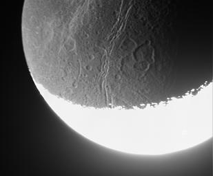 NASA's Cassini spacecraft whizzed past Dione on Aug. 16, 2006, capturing this slightly motion-blurred view of the moon's fractured and broken landscape in reflected light from Saturn.
