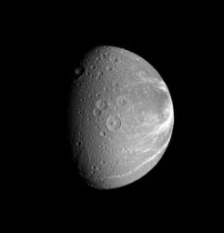 Bright fractures creep across the surface of icy Dione. This extensive canyon system is centered on a region of terrain that is significantly darker that the rest of the moon in this image captured by NASA's Cassini spacecraft on Sept. 27, 2006.