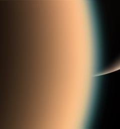 Cassini peers around the hazy limb of Titan to spy the sunlit south pole of Saturn in the distance beyond in this image taken by NASA's Cassini spacecraft on Dec. 26, 2005.