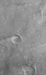 NASA's Mars Global Surveyor shows terrain southwest of Meroe Patera in Syrtis Major Planum, Mars. Impact craters are common throughout the scene, including a small impact crater with light-toned ejecta radiating outward from its rim.