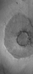 This image from NASA's Mars Global Surveyor shows a pedestal a 'pancake' or 'pedestal' crater on the martian northern plains. The rocky ejecta from the crater protected the underlying material from being stripped away by wind.