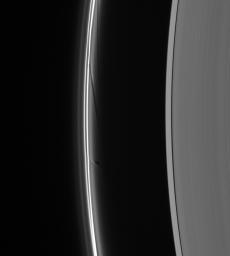 Prometheus dips into the inner F ring at its farthest point from Saturn in its orbit, creating a dark gore and a corresponding bright streamer as seen by NASA's Cassini spacecraft.