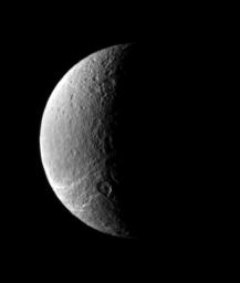 This view looks toward Rhea's north polar region, where icy fractures slither away toward the south as seen by NASA's Cassini spacecraft.