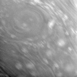 This close-up view of Saturn's atmosphere shows a circular vortex surrounded by numerous attendant bright clouds. Some blurring due to spacecraft motion is apparent as seen by NASA's Cassini spacecraft.