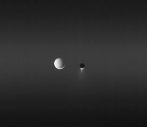 Sunlight makes visible the faint band called the E ring as two of Saturn's moons, Enceladus and Tethys, meet in the sky. Enceladus' brilliant plume of ice erupting from its south pole as seen by NASA's Cassini spacecraft.
