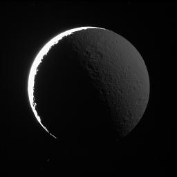 The night side of Rhea shines softly in reflected light from Saturn, as captured in this image from NASA's Cassini spacecraft. A similar effect, called Earthshine, can often be seen dimly illuminating the dark side Earth's moon.