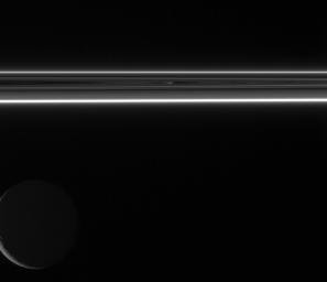 Two small portions of Saturn's F ring shine brilliantly in scattered sunlight as Rhea floats in the distance beyond. This image was taken in visible light with NASA's Cassini spacecraft's wide-angle camera.
