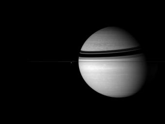 Saturn sits with its attendants in the icy depths of the outer Solar System in this image from NASA's Cassini spacecraft.