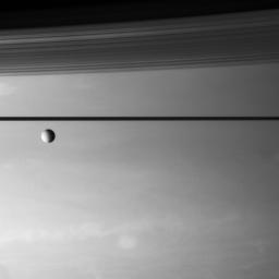 An icy moon drifts above the stormy skies of Saturn. This image was taken with NASA's Cassini spacecraft's narrow-angle camera on Aug. 15, 2007.