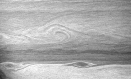 Large vortices edge their way along the turbulent boundary between east-west flowing cloud bands. This view captured by NASA's Cassini spacecraft is centered on a region 22 degrees south of Saturn's equator.