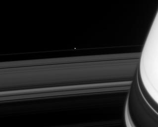 Across the darkened expanse of Saturn's rings, NASA's Cassini spacecraft spied one of the F-ring shepherd moons, Pandora, in 2008.
