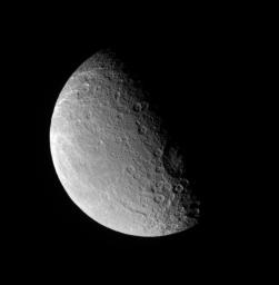 NASA's Cassini spacecraft looks down onto middle northern latitudes on Rhea. The large Tirawa basin is seen on the terminator at right.