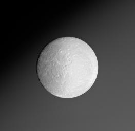 Rhea drifts in front of Saturn. The battered, icy moon is seen here near the western limb of the planet's northern hemisphere. This image was taken with NASA's Cassini spacecraft's narrow-angle camera on Jan. 17, 2008.