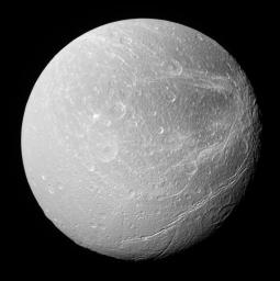 This southerly view of Saturn's moon Dione captured by NASA's Cassini spacecraft shows enormous canyons extending from mid-latitudes on the trailing hemisphere, at right, to the moon's south polar region.