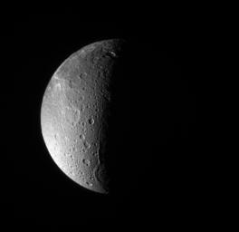 NASA's Cassini spacecraft looks down, almost directly at the north pole of Saturn's moon, Dione. The feature just left of the terminator at bottom is Janiculum Dorsa, a long, roughly north-south trending ridge.