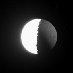 As Cassini images often show, the Sun is not the only source of illumination in the Saturn System. The huge, reflective planet also shines upon its moons. This image from NASA's Cassini spacecraft looks almost directly down onto the north pole of Dione.